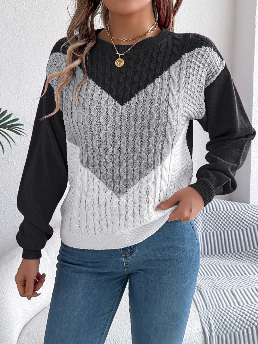 Chevron cable knit sweater with contrast black, gray, and white colorblock pattern.