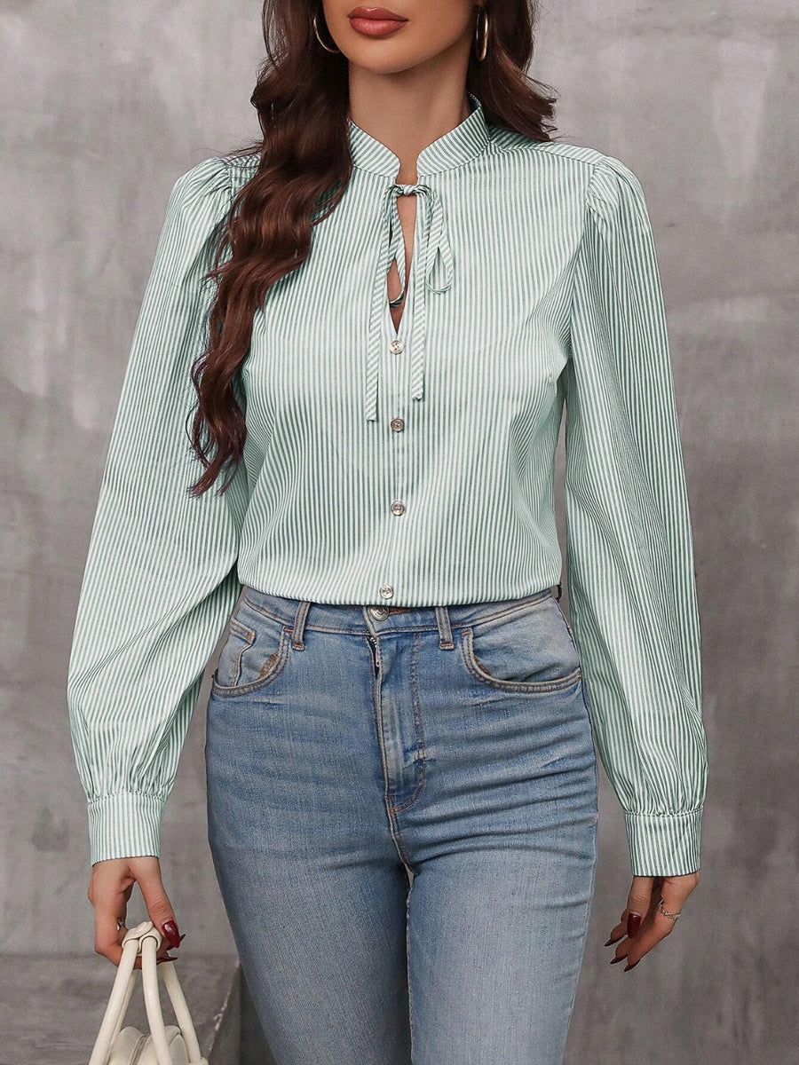 Green striped blouse with puff sleeves and neck tie detail.