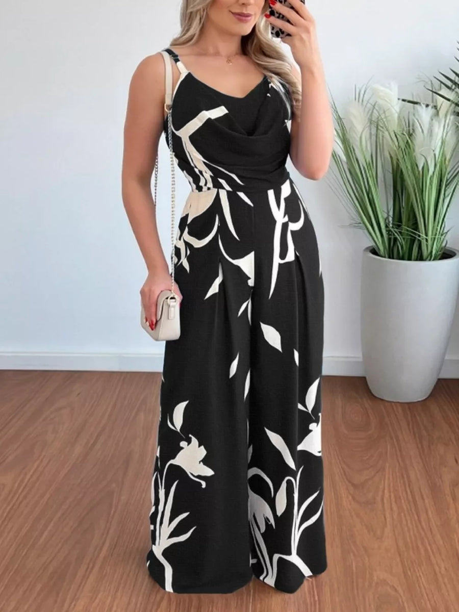 Black abstract leaf print wide-leg jumpsuit with cowl neck and adjustable straps.