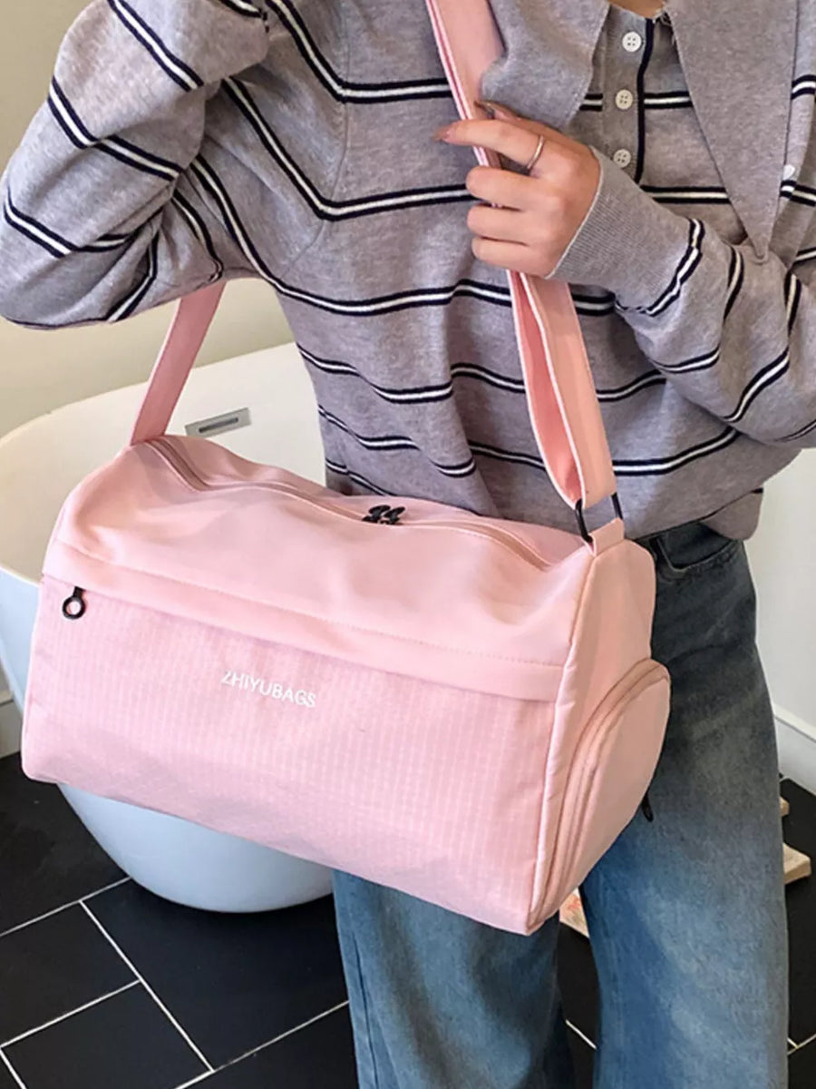 Pink travel organizer bag with textured panel and side pocket