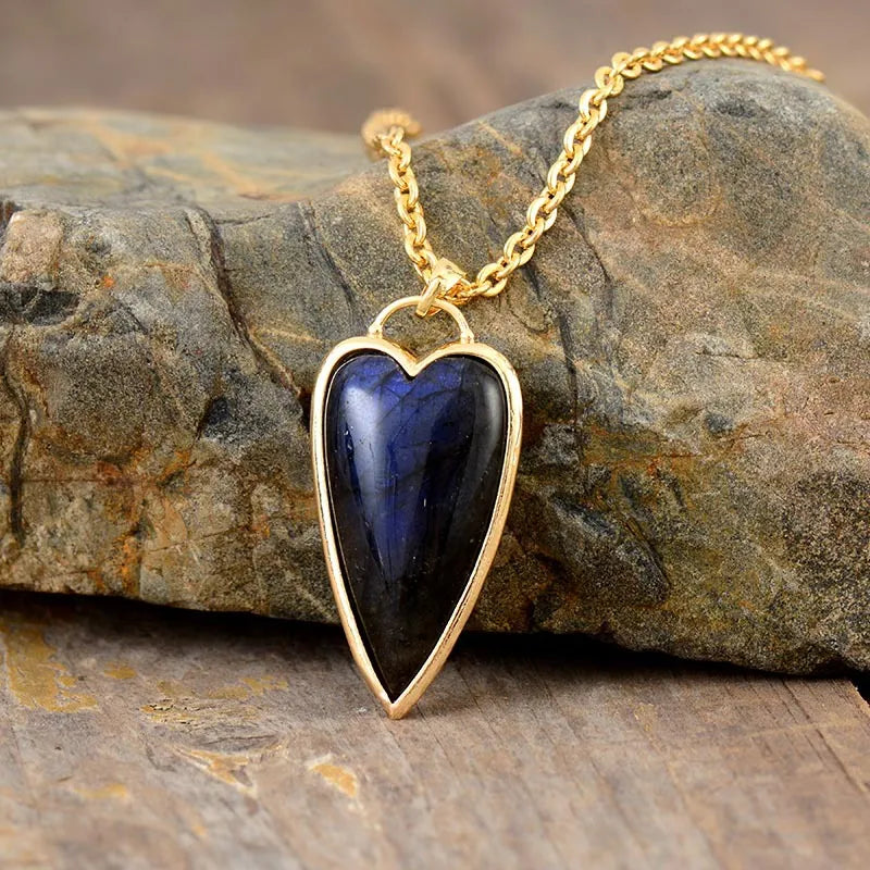 Gold chain necklace with a heart-shaped labradorite pendant, boho style.