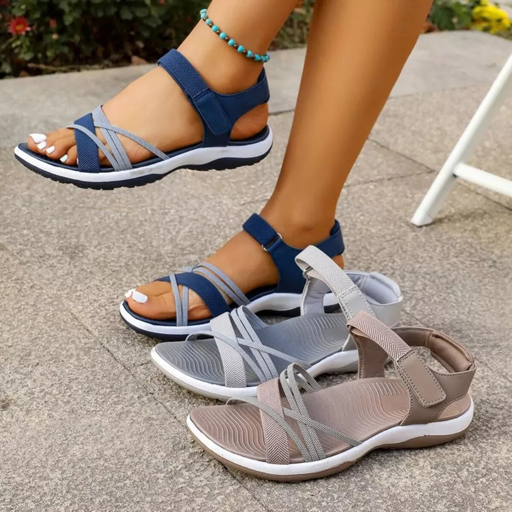 Blue, gray, and khaki adjustable open-toe sandals with criss-cross straps and white soles.
