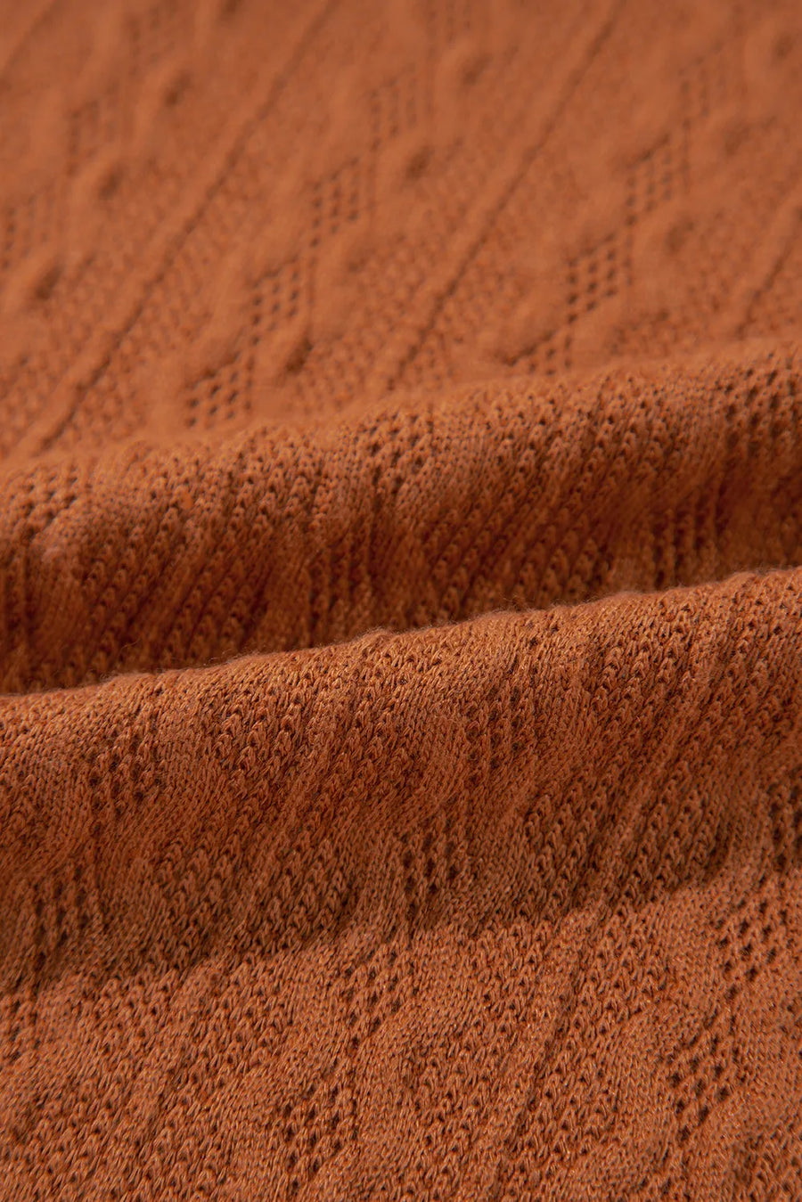 Terracotta open front cardigan with diamond knit detail and open weave texture.