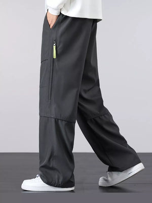 Men's gray loose fit cargo pants with zippered pocket detail and drawstring waist.
