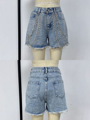 Sky blue denim shorts with rhinestone chain embellishments and frayed hem.