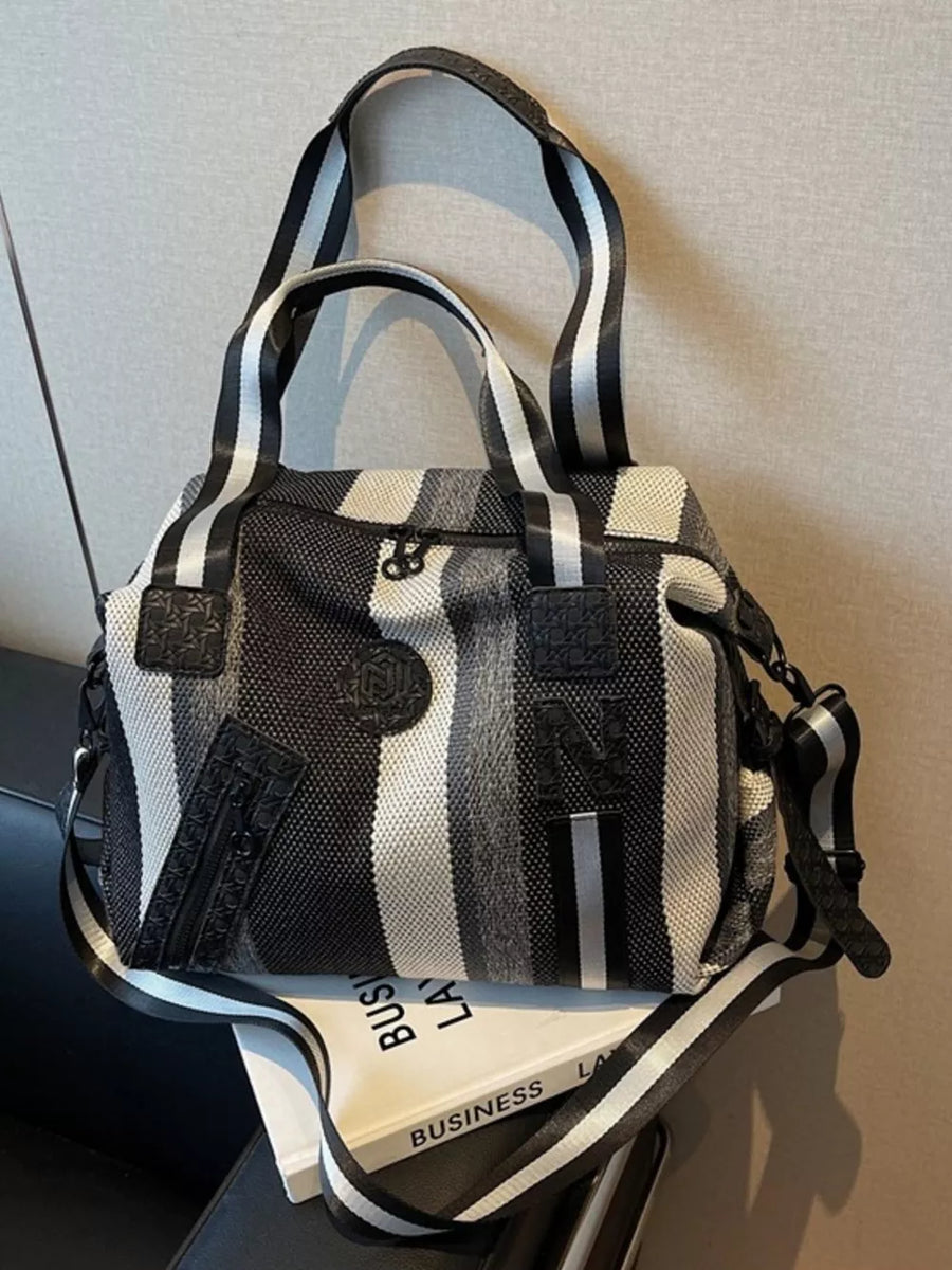 Chic striped medium duffle bag with black and white stripes and a detachable strap.