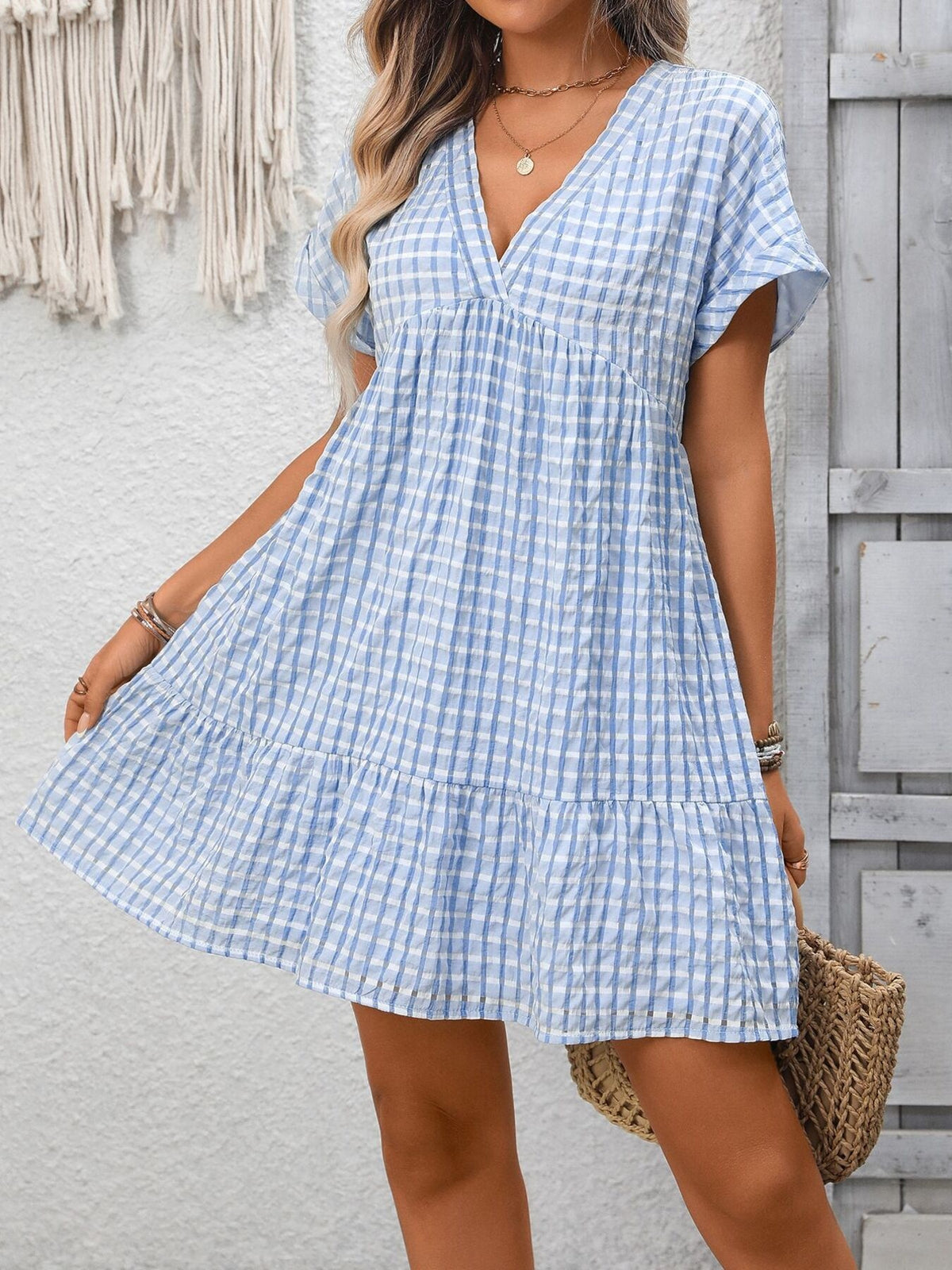 Light blue plaid V-neck mini dress with short sleeves and tiered hem.