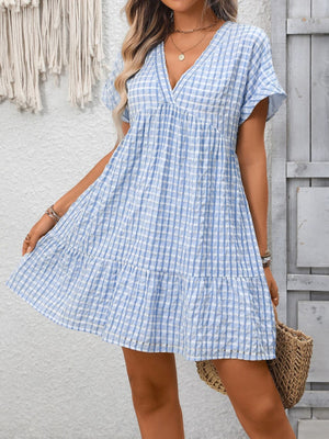 Light blue plaid V-neck mini dress with short sleeves and tiered hem.