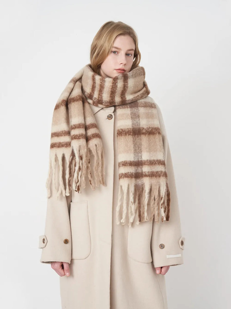 Textured plaid fringe wrap scarf in brown and tan, styled with a cream coat.