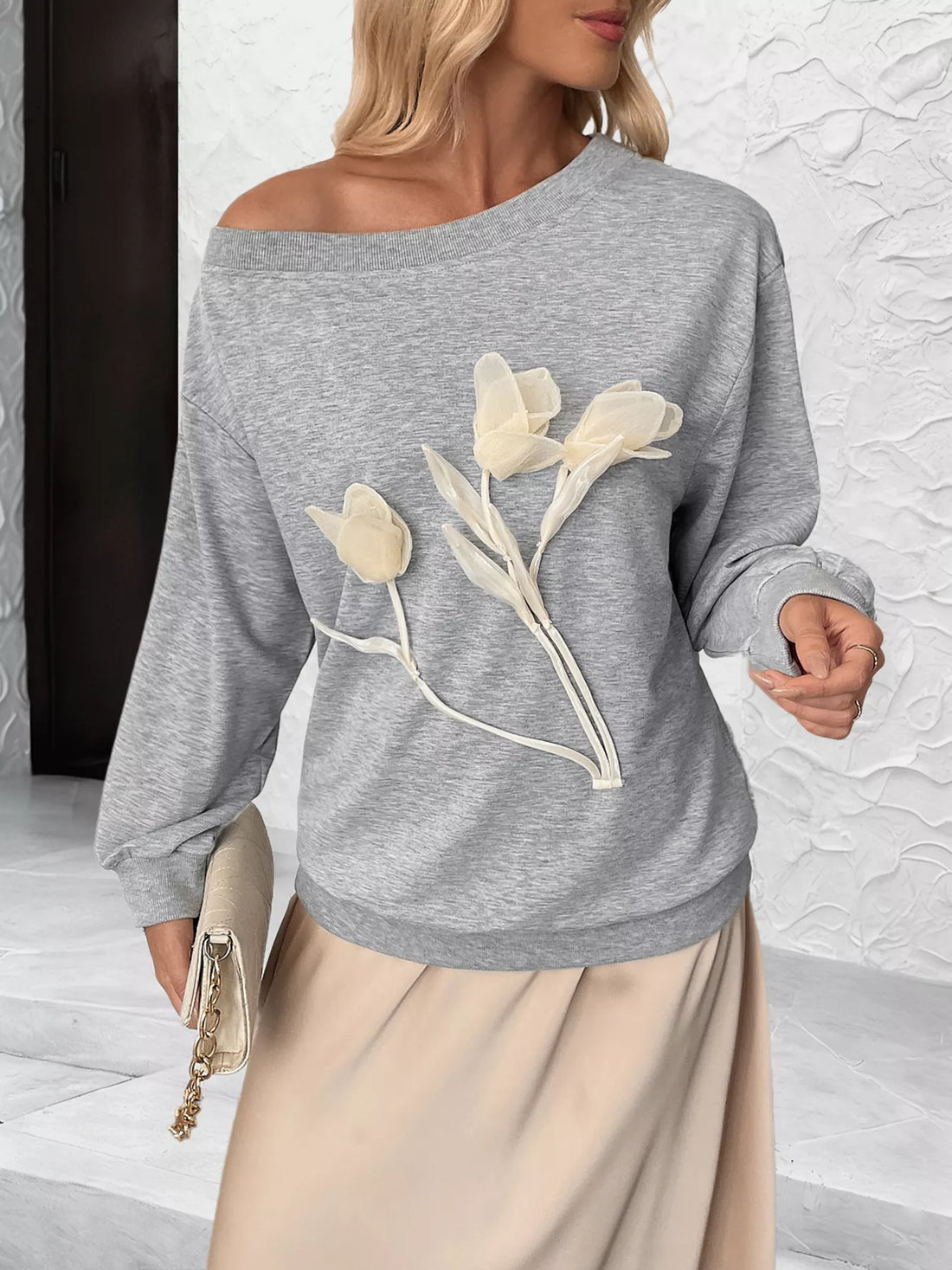 Gray boat neck sweater with sheer floral applique detail.