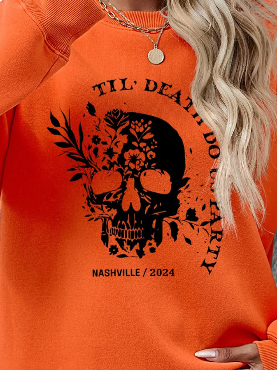 Orange sweatshirt with floral skull graphic and text.