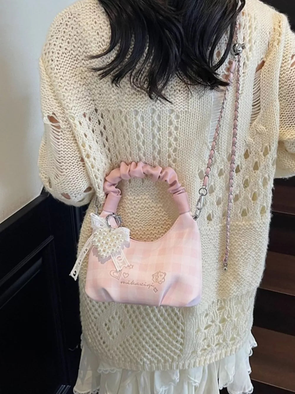 Charming mini crossbody bag in blush pink with ruched handle and heart charm.