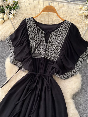 Black embroidered V-neck boho maxi dress with tie waist and flutter sleeves.