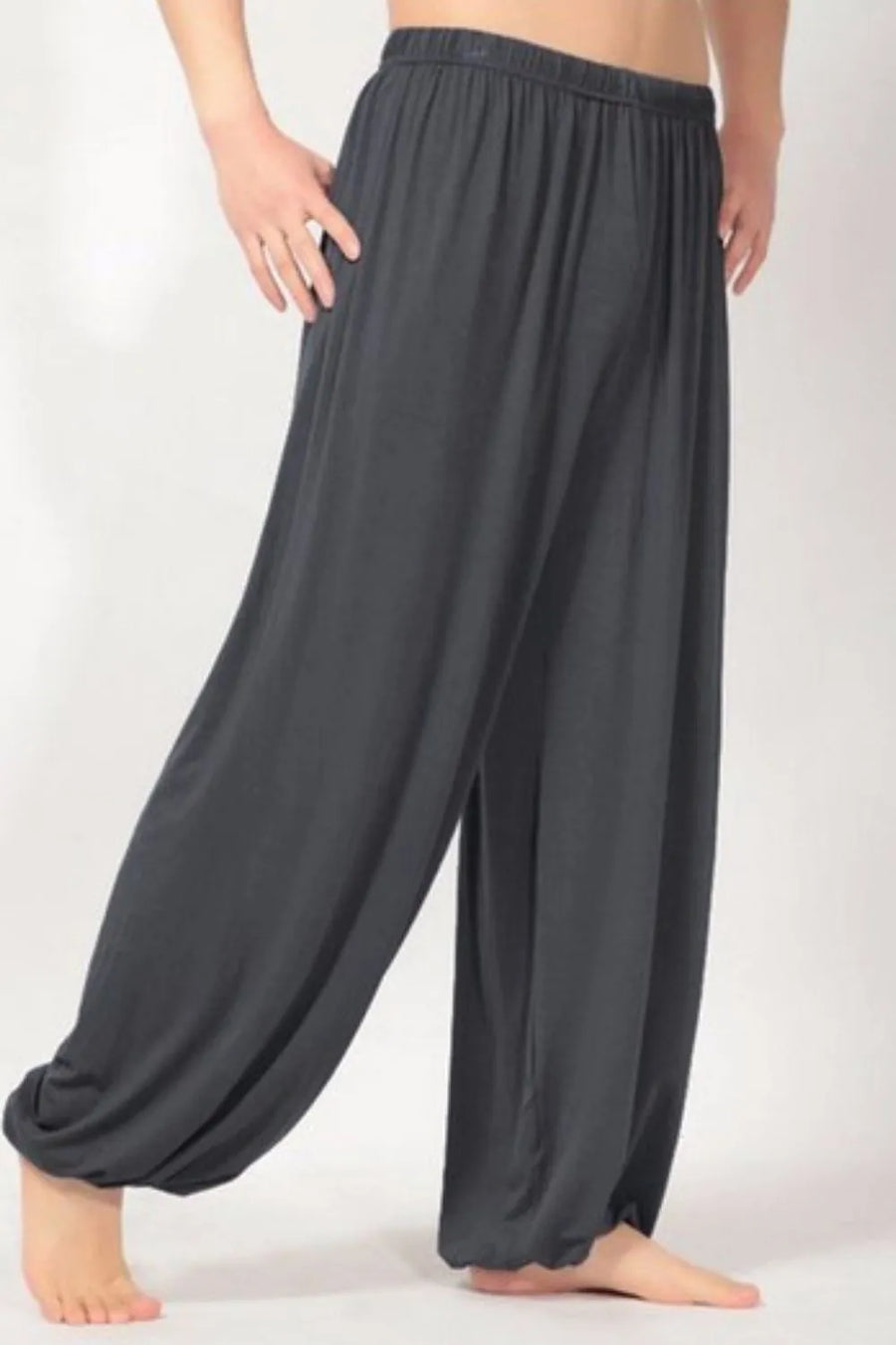 Dark gray relaxed drape harem pants with elastic waistband and cinched ankles.