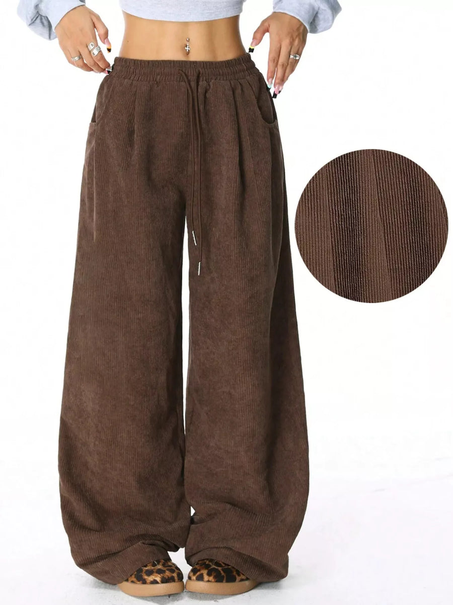 Brown corduroy pants with drawstring waist and wide leg, showing fabric texture.