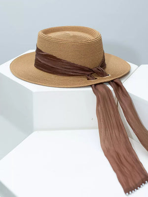 Brown straw sun hat with ribbon and pearl embellishments