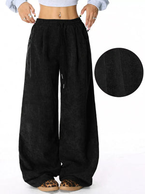 Black corduroy drawstring pants with a relaxed fit and wide leg.