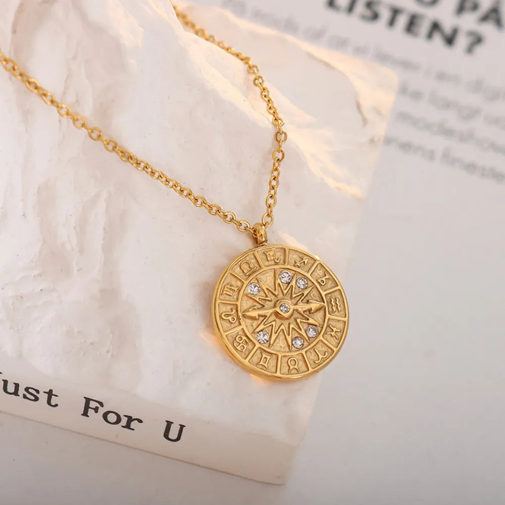 Gold zodiac compass pendant necklace with crystal accents and a celestial design.