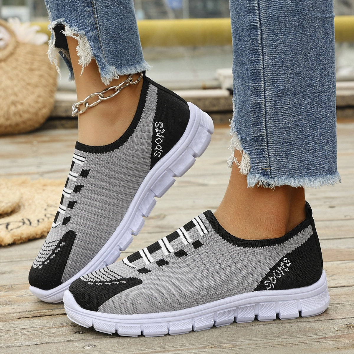 Mesh slip-on sneakers in grey and black with white soles and "Sports" detail.