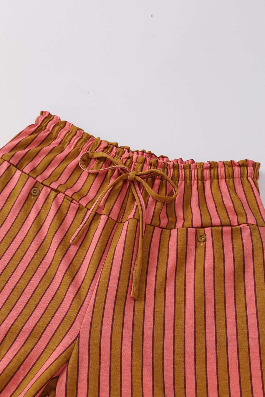Wide leg pants in pink and brown stripes with drawstring waist and button pocket detail.