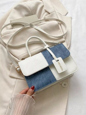 Chic two-tone PU leather crossbody bag in white and denim blue with a flap closure and tag.