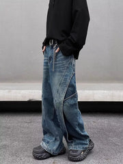 Men's washed wide-leg jeans in blue denim with distressed details and diagonal seams.