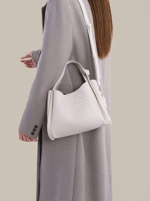 crossbody bag in cream featuring adjustable strap and soft structured fit