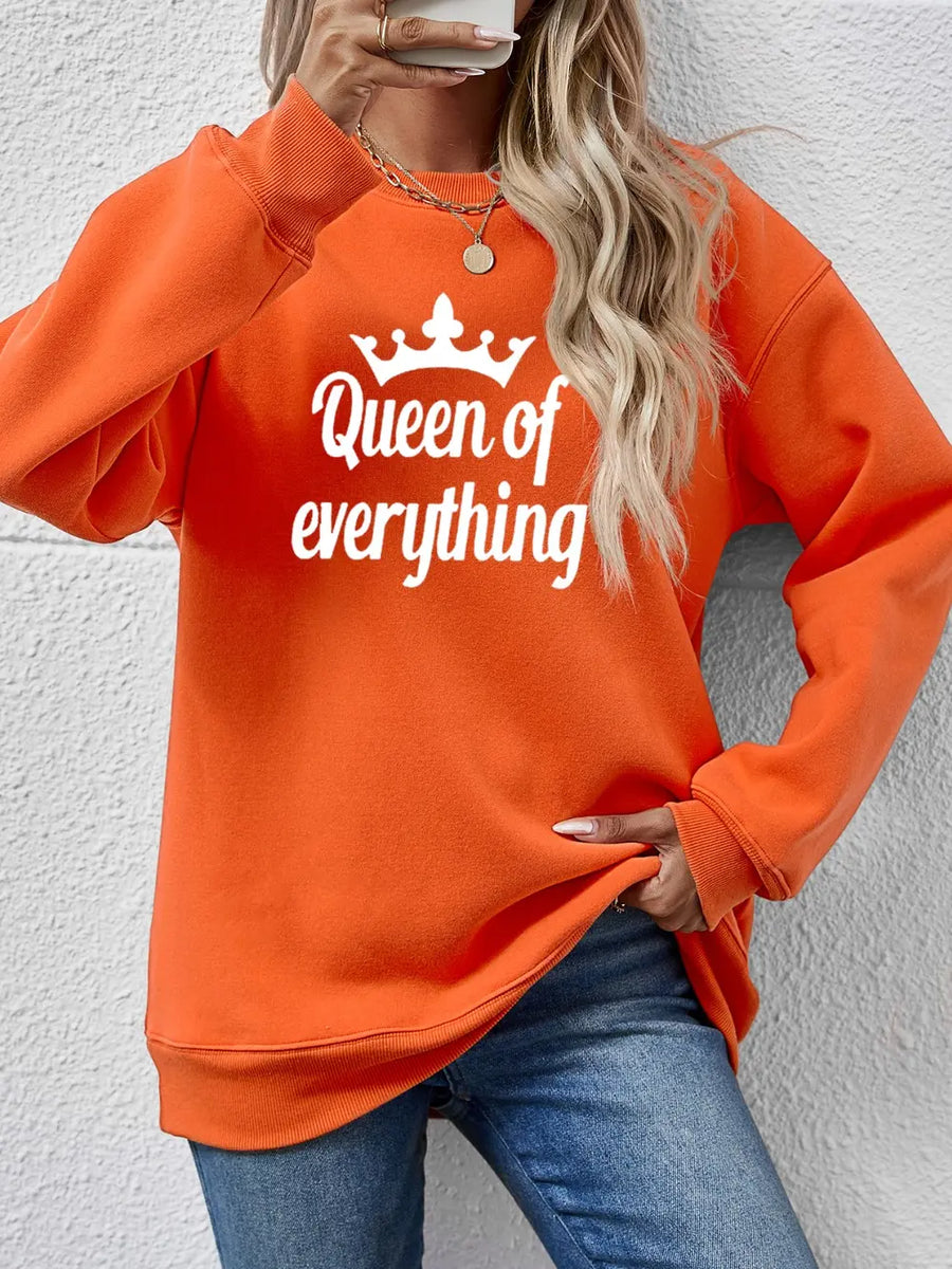 Orange graphic sweatshirt with white Queen of Everything text and crown detail.