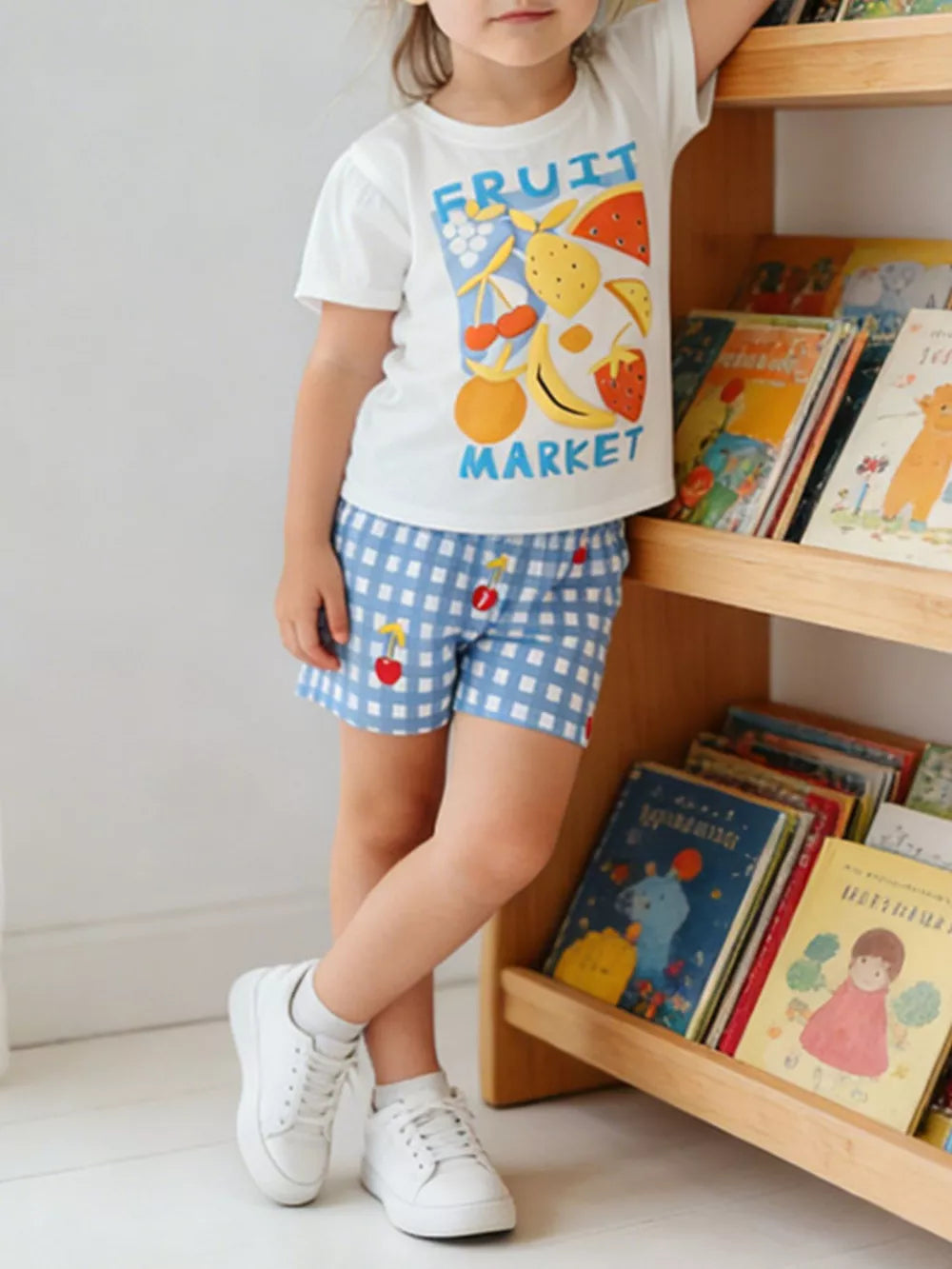 Baby girls' white cotton tee with fruit market graphic and blue gingham shorts with cherry detail.