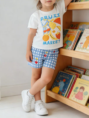 Baby girls' white cotton tee with fruit market graphic and blue gingham shorts with cherry detail.