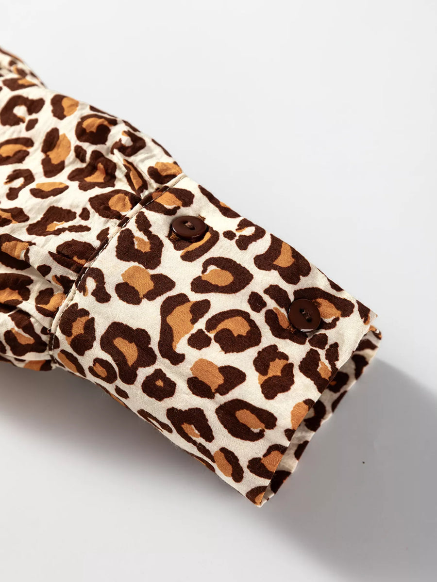 Leopard print button-down shirt cuff with two brown buttons and frilled trim detail.