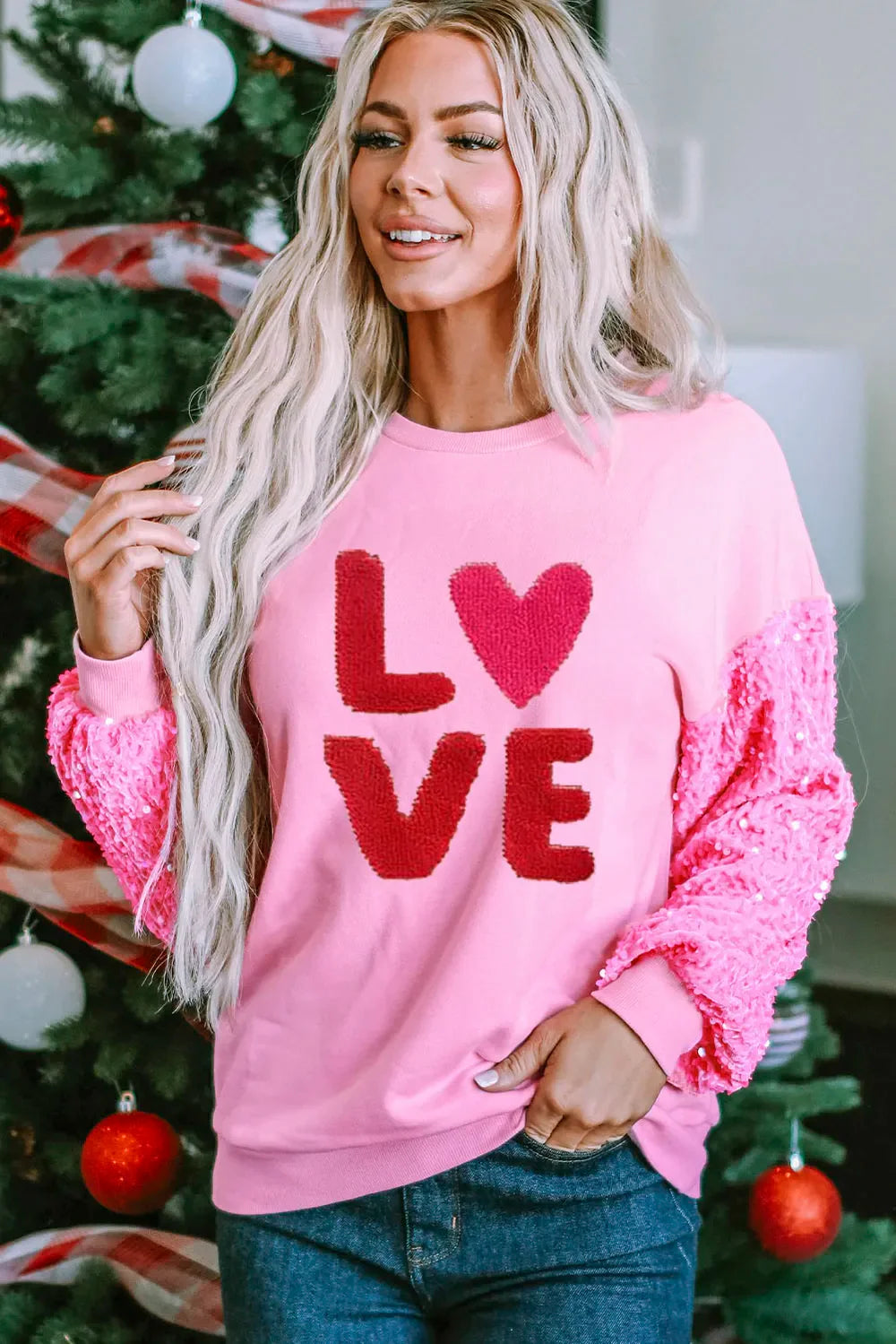 Pink sweatshirt with red sequin sleeves and "LOVE" appliqué.