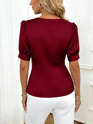 Burgundy satin wrap blouse with puff sleeves and a V-neckline.