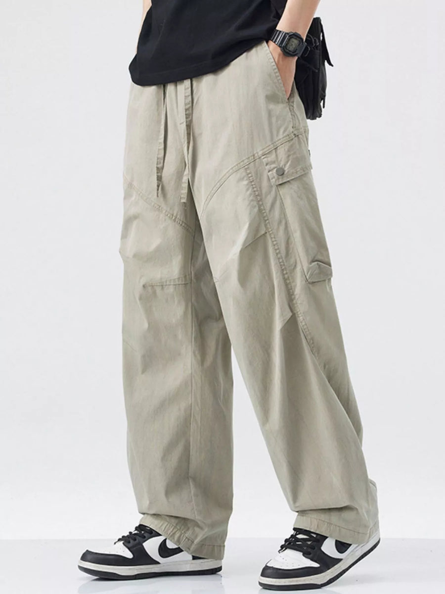 Loose fit khaki cargo pants with drawstring waist and multiple pockets.
