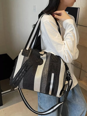 Chic striped medium duffle bag with detachable strap and black accents.