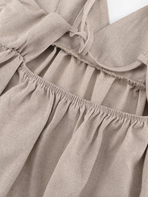 Beige linen cami with ruffled square neckline and tie straps.