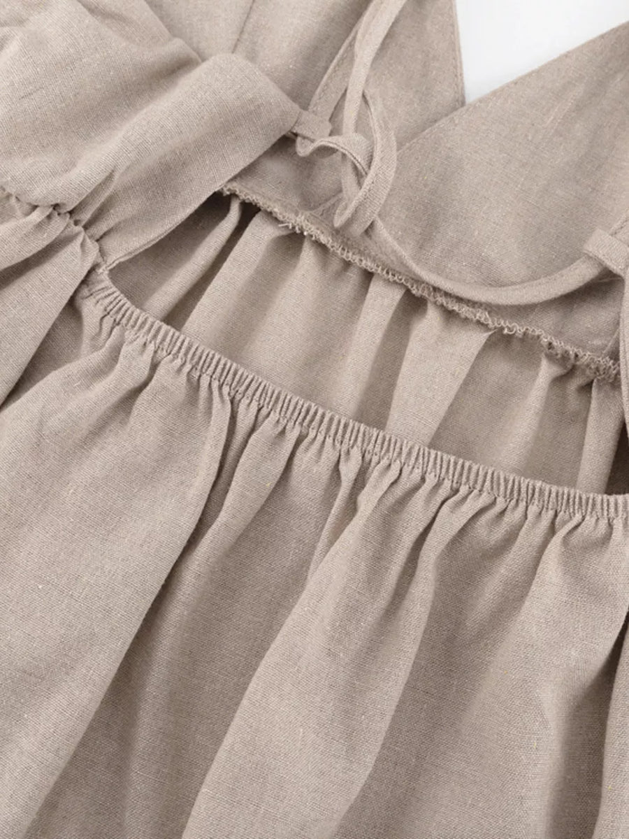 Beige linen cami with ruffled square neckline and tie straps.