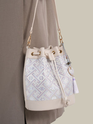 light purple crossbody bag featuring drawstring closure and geometric