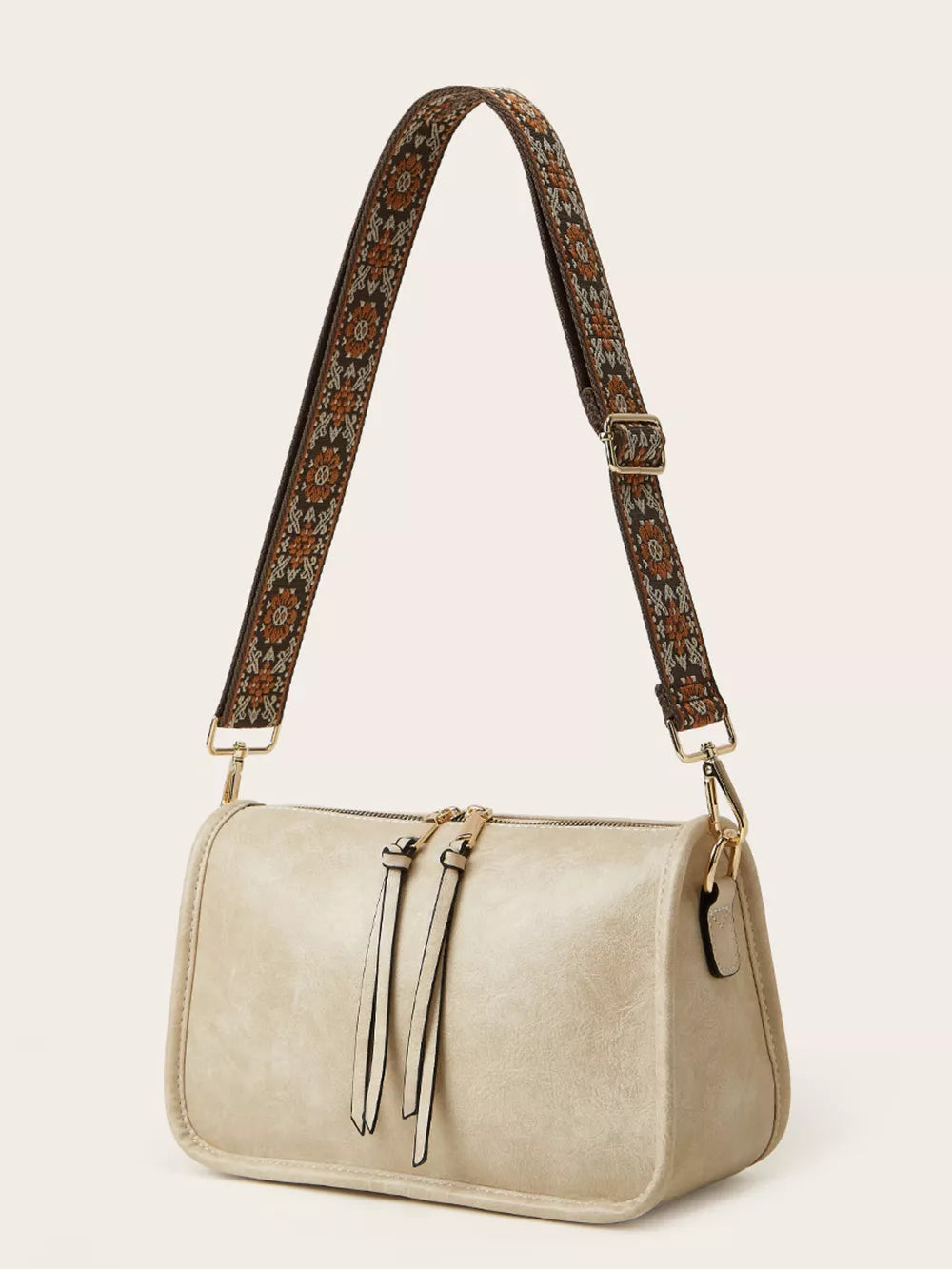 Ivory crossbody bag with bohemian patterned strap and tassel zipper pulls