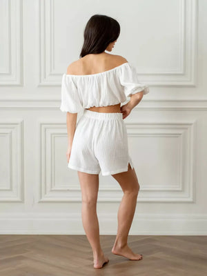 White cotton off-shoulder cropped top and shorts set with elastic waist and side slit shorts.