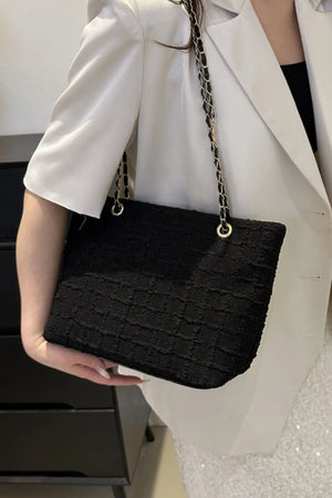 Black bouclé shoulder bag with gold chain strap detail