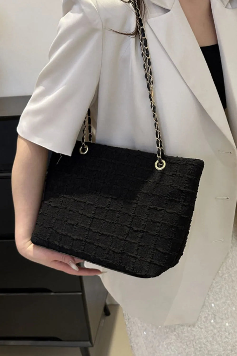 Black bouclé shoulder bag with gold chain strap detail