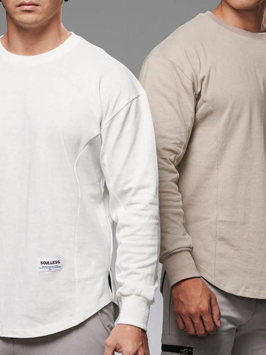 Oversized long sleeve tee in white with curved hem and side panel detail.