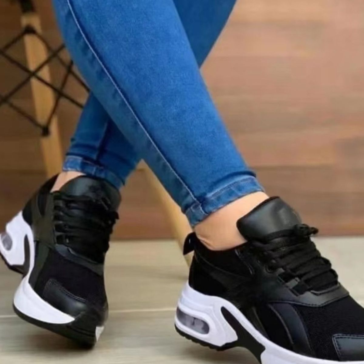 Black lace up air cushion sneakers with white chunky soles and visible air cushioning.