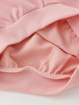 Pale blush cotton crew neck sweatshirt detail showing soft brushed interior fabric.