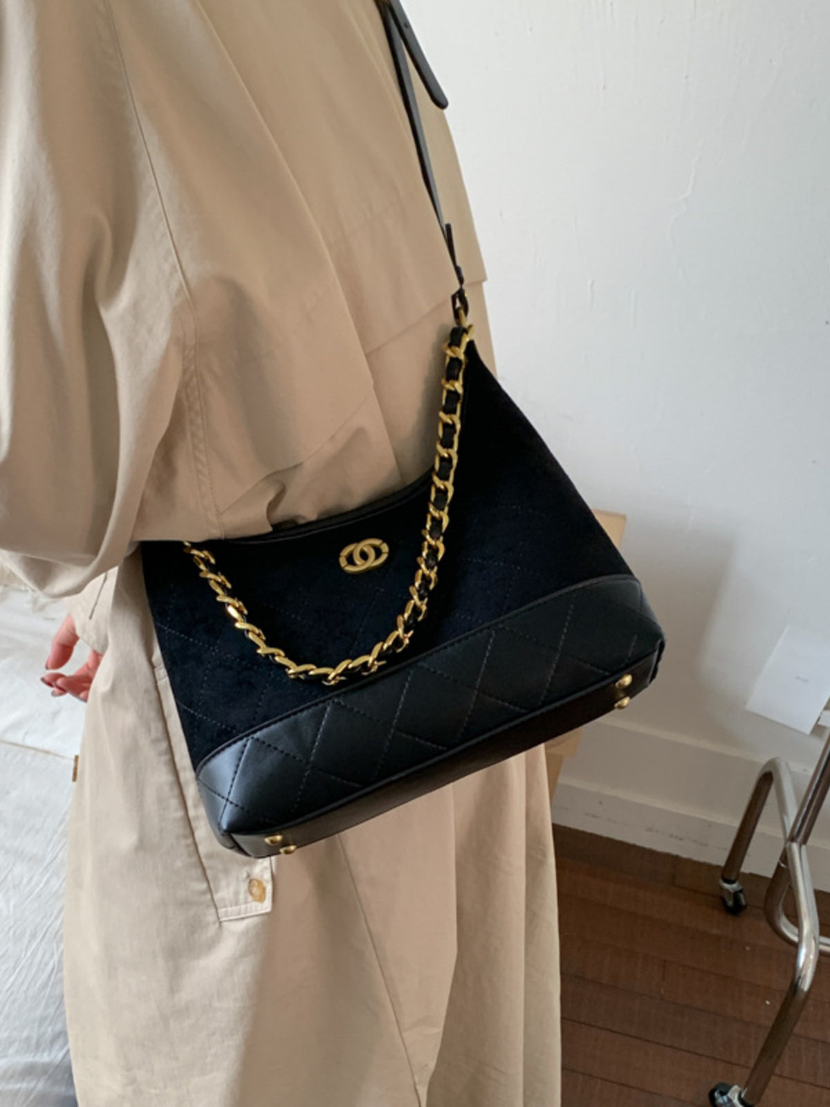 Black crossbody bag with chain detail and quilted bottom panel.