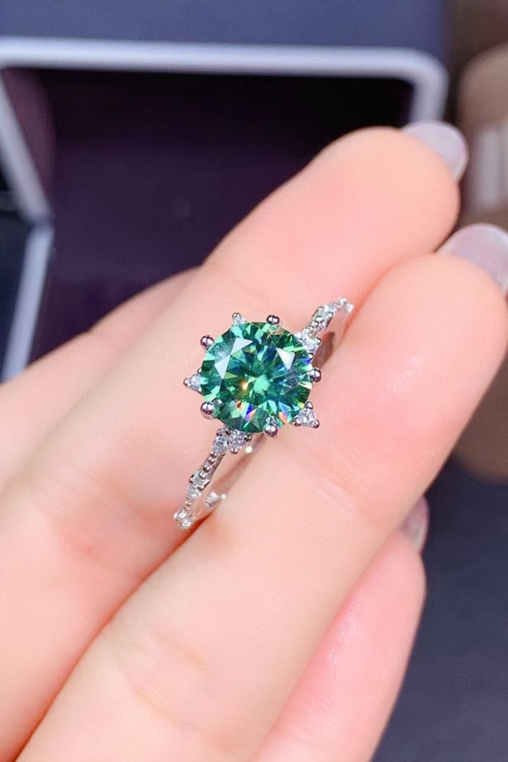 Emerald cut green moissanite ring with celestial halo on platinum band