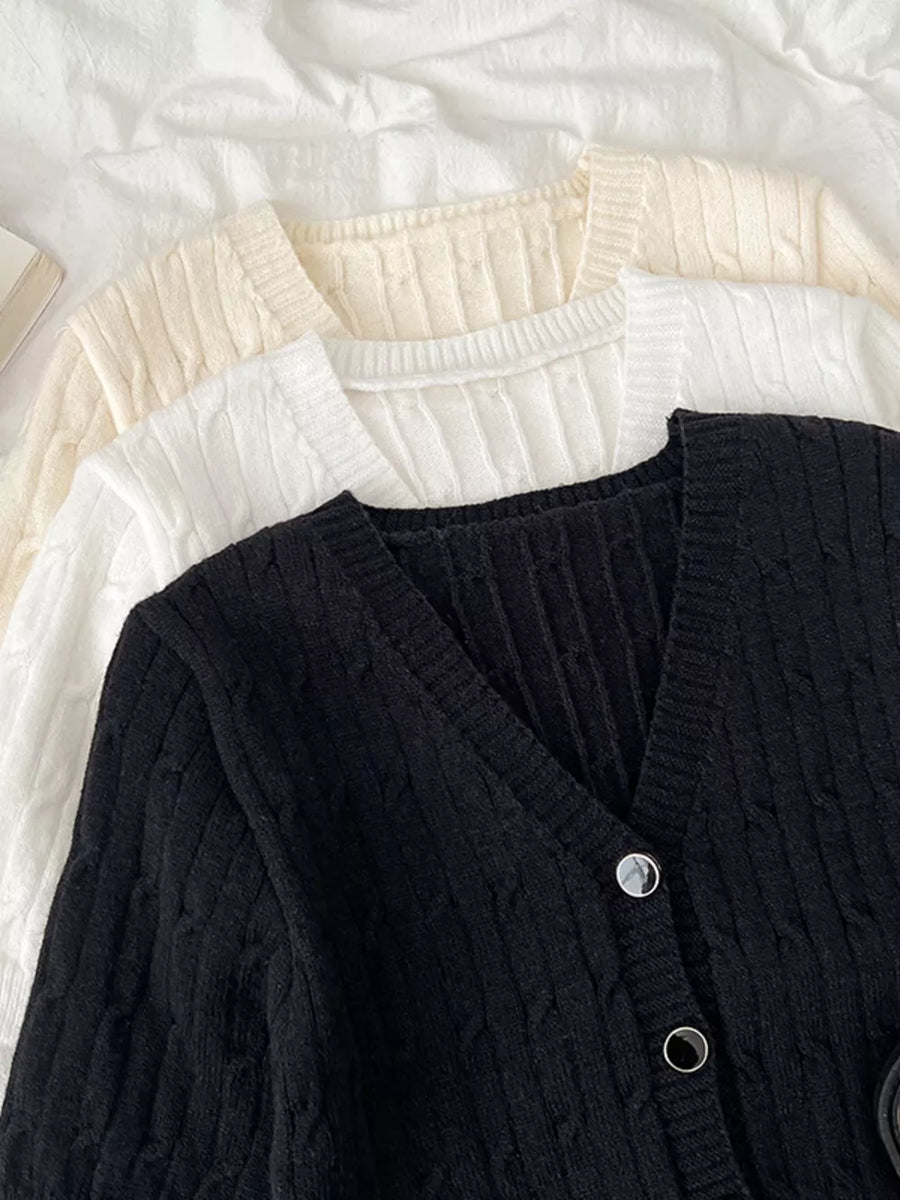 Black cable-knit cropped cardigan with V-neck and button details.