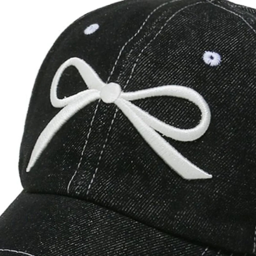 Black denim baseball cap with white embroidered bow detail