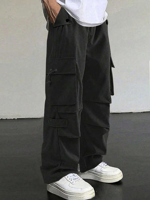 Black cargo pants with multiple pockets and drawstring details, styled with white sneakers.